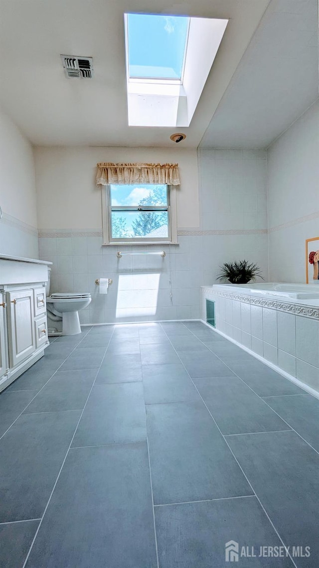 20 Ballo Pl, Edison, NJ 08820 - bathroom featuring tile walls, a skylight, tile patterned flooring, vanity, and tiled tub