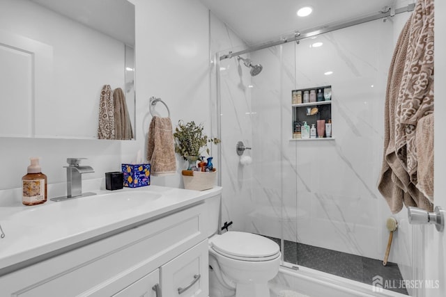 full bath with a marble finish shower, vanity, recessed lighting, and toilet