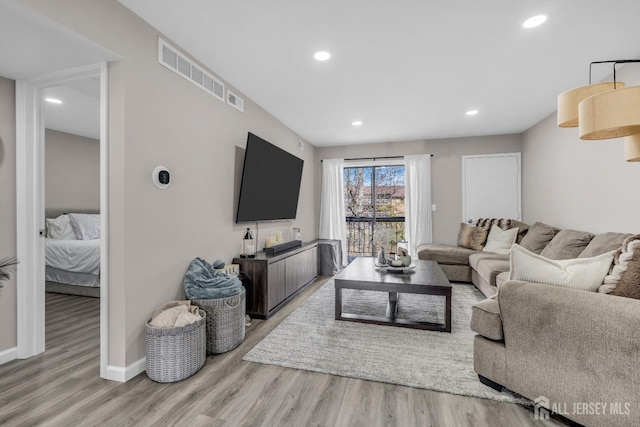 living room featuring wood finished floors, recessed lighting, and baseboards