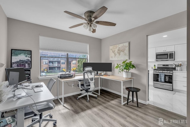 home office with ceiling fan, light wood-style floors, and baseboards