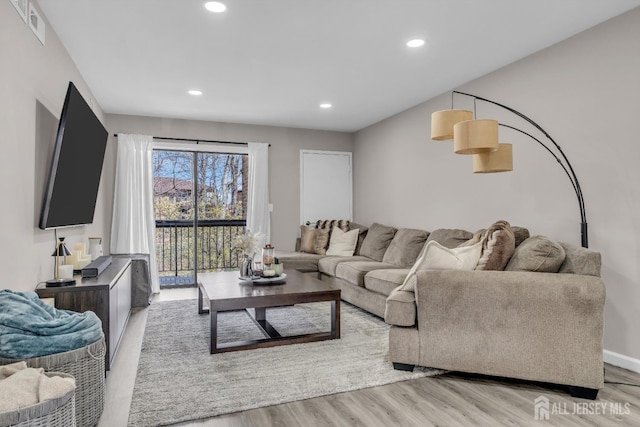 living room with light wood-type flooring and recessed lighting