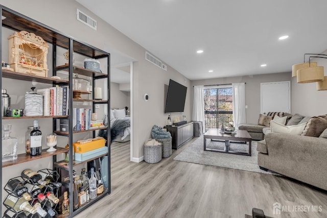 living area with wood finished floors, recessed lighting, and baseboards