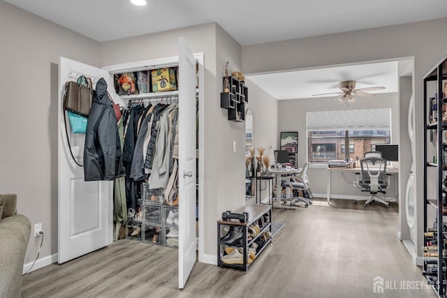 walk in closet with wood finished floors and ceiling fan