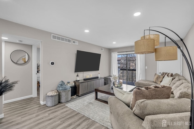living room with wood finished floors, recessed lighting, and baseboards