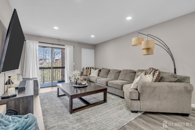 living area with light wood finished floors and recessed lighting