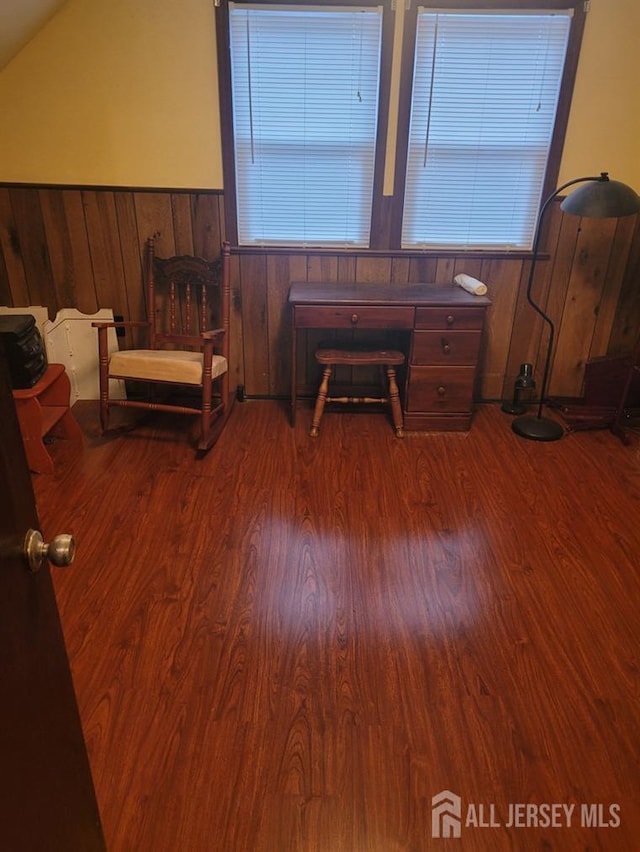bedroom featuring wood walls, wainscoting, vaulted ceiling, and wood finished floors