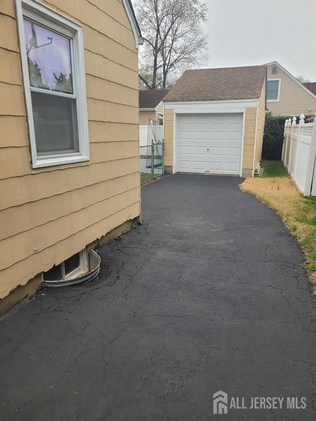 150 Morton Ave, South Plainfield, NJ 07080 - view of property exterior with an outbuilding, fence, asphalt driveway, and a detached garage
