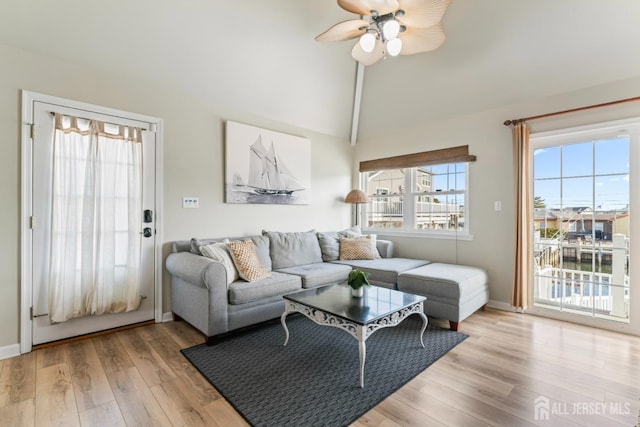 living room with ceiling fan, high vaulted ceiling, and light hardwood / wood-style floors