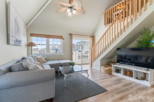 living room featuring stairs, ceiling fan, high vaulted ceiling, and wood finished floors