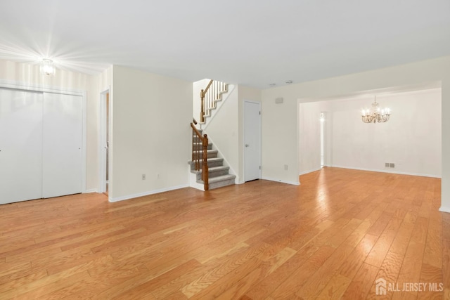 7 Tisbury Ct, Scotch Plains, NJ 07076 - unfurnished living room with a chandelier, light wood-type flooring, and stairs
