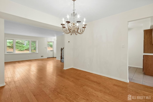 7 Tisbury Ct, Scotch Plains, NJ 07076 - unfurnished room with light wood-style flooring, a chandelier, and stairway