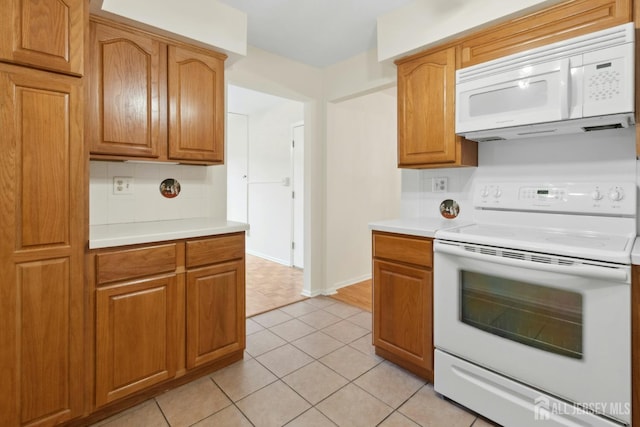 7 Tisbury Ct, Scotch Plains, NJ 07076 - kitchen with white appliances, decorative backsplash, light countertops, brown cabinets, and light tile patterned floors
