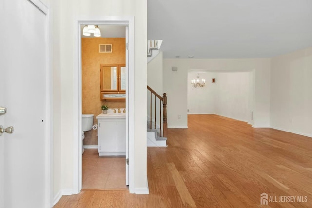 7 Tisbury Ct, Scotch Plains, NJ 07076 - corridor featuring a chandelier, stairway, and light wood finished floors