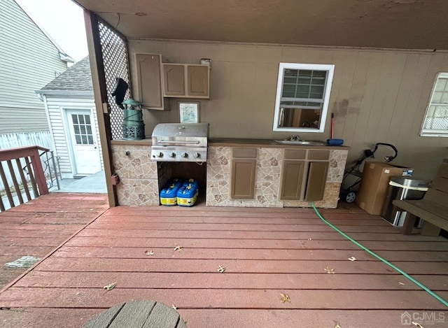 wooden deck featuring an outdoor kitchen, grilling area, and sink