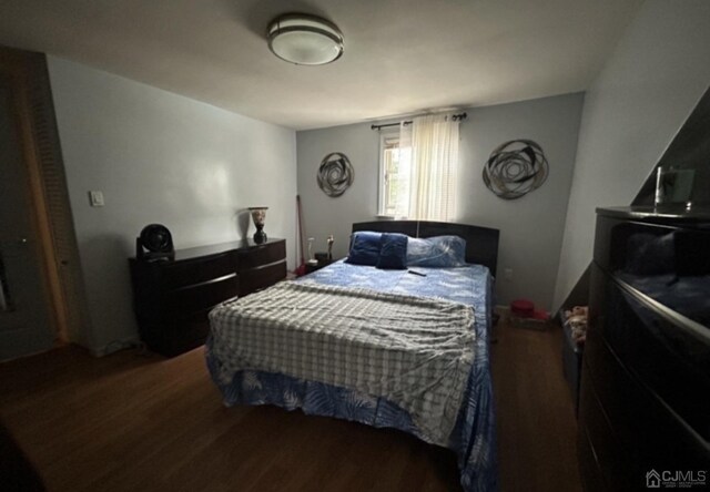 bedroom with dark hardwood / wood-style floors