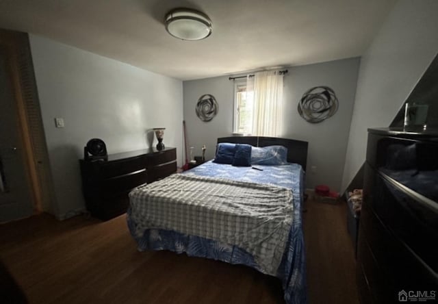 bedroom with dark wood-type flooring