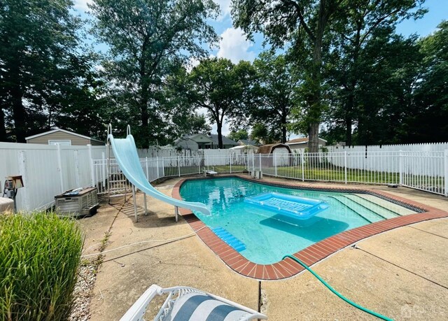 view of pool with a patio and a water slide