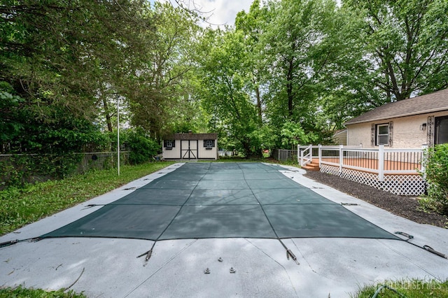 144 Elm St, Dover, NJ 07801 - view of pool with a wooden deck, a storage unit, view of wooded area, and a patio