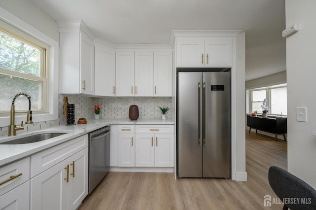 144 Elm St, Dover, NJ 07801 - kitchen with stainless steel appliances, light wood finished floors, tasteful backsplash, white cabinets, and an office area