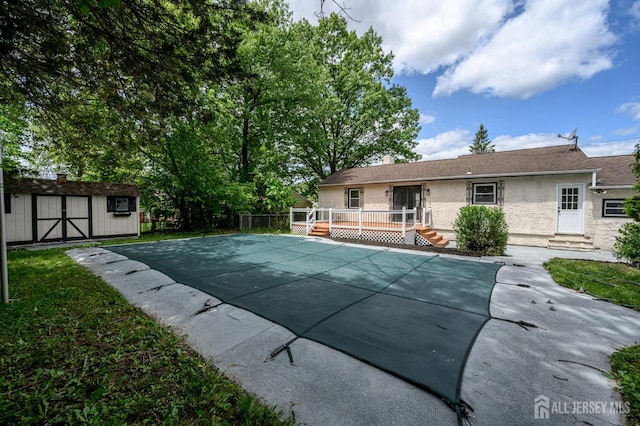 144 Elm St, Dover, NJ 07801 - view of swimming pool featuring a deck, a covered pool, a shed, and entry steps