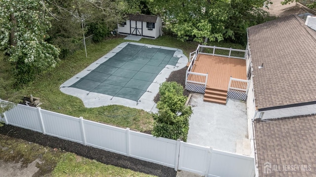 144 Elm St, Dover, NJ 07801 - view of swimming pool featuring a deck, a fenced backyard, and a storage unit