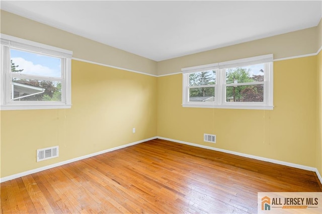 empty room featuring baseboards and light wood-type flooring