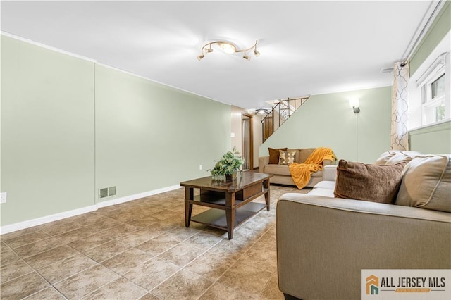 living area featuring stairs and baseboards