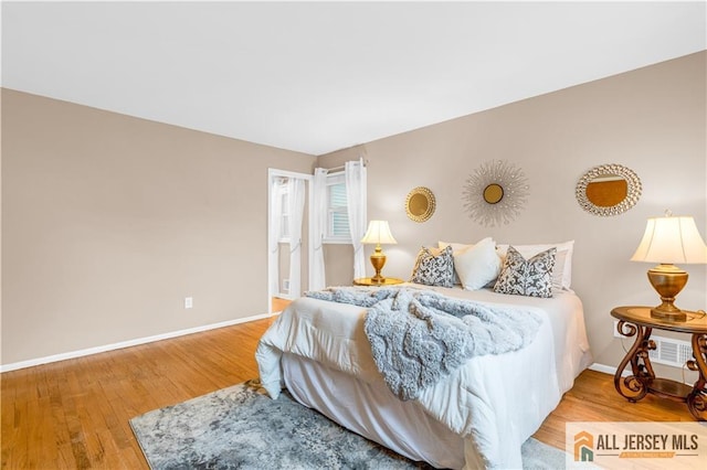 bedroom featuring baseboards and wood finished floors