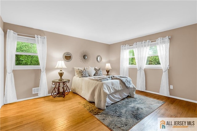 bedroom with hardwood / wood-style floors and baseboards