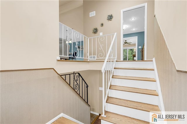 stairs featuring a ceiling fan and baseboards