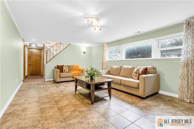 living area with stairway, baseboards, crown molding, and light tile patterned floors
