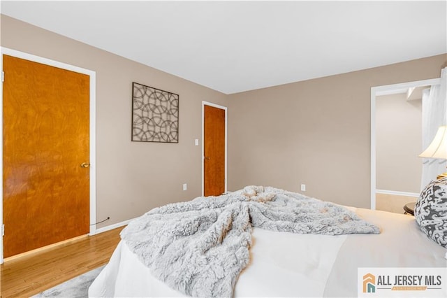 bedroom with wood finished floors and baseboards