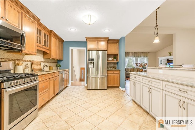 kitchen with appliances with stainless steel finishes, backsplash, light stone counters, glass insert cabinets, and pendant lighting
