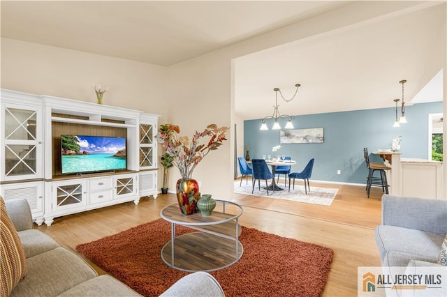 living area with wood finished floors, baseboards, and lofted ceiling