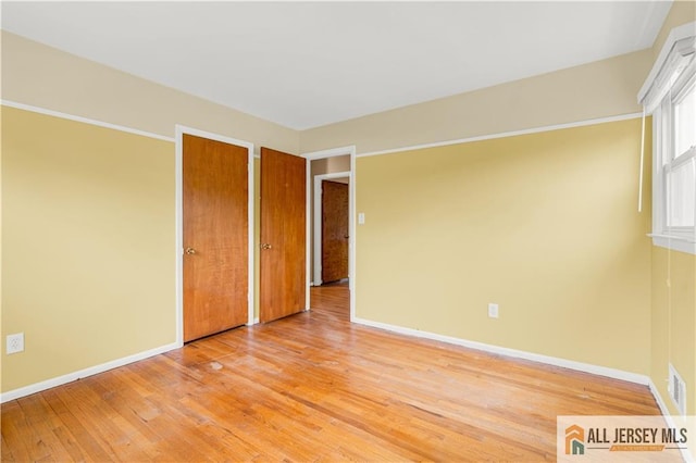 spare room with light wood-type flooring and baseboards