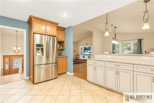kitchen with stainless steel fridge, a chandelier, vaulted ceiling, light tile patterned floors, and hanging light fixtures
