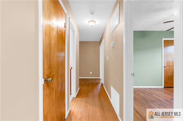 hall featuring hardwood / wood-style flooring and baseboards