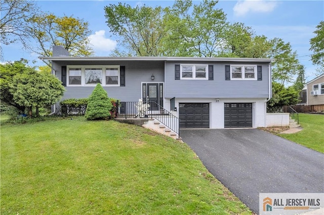 split foyer home featuring a garage, asphalt driveway, and a chimney
