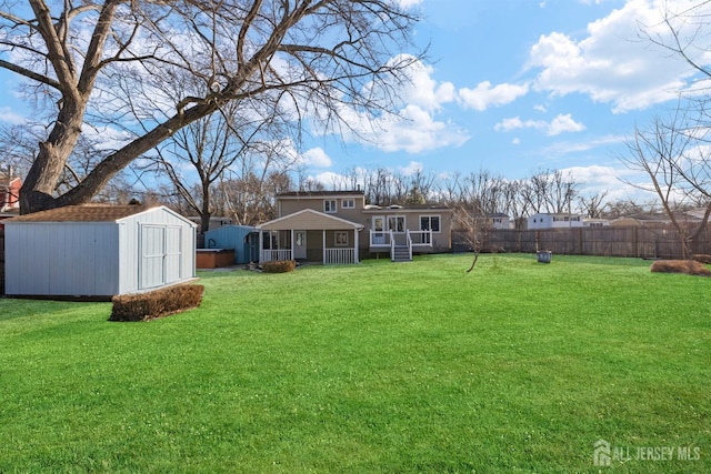 view of yard with an outdoor structure, fence, and a storage unit