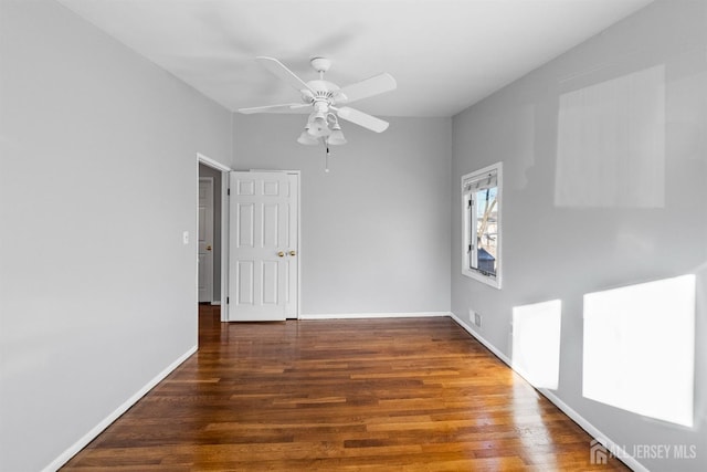 unfurnished room featuring visible vents, dark wood finished floors, baseboards, and ceiling fan