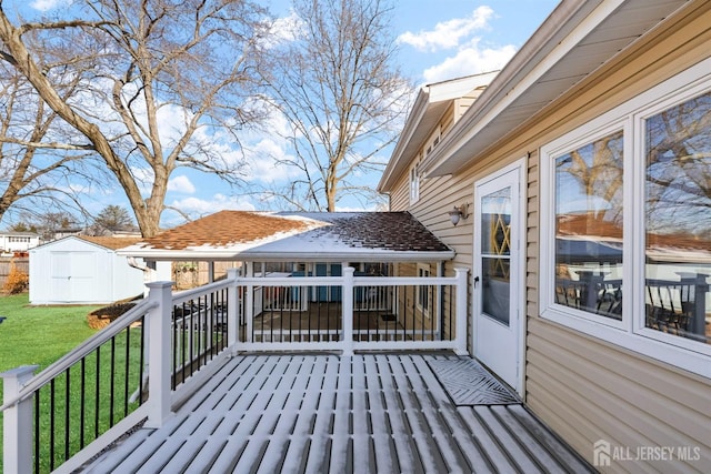 wooden terrace with a storage shed, a lawn, and an outdoor structure