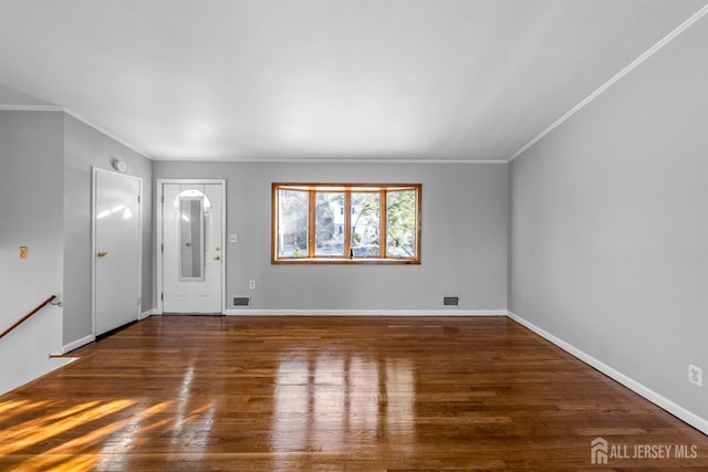 foyer featuring ornamental molding, dark wood-type flooring, visible vents, and baseboards