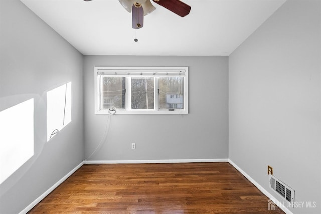 spare room featuring ceiling fan, wood finished floors, visible vents, and baseboards