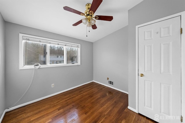 unfurnished room with baseboards, visible vents, ceiling fan, and dark wood-type flooring