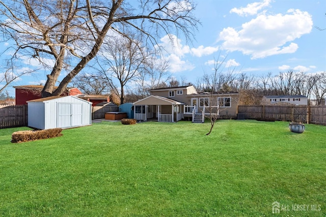 view of yard with a storage unit, an outdoor structure, and a fenced backyard