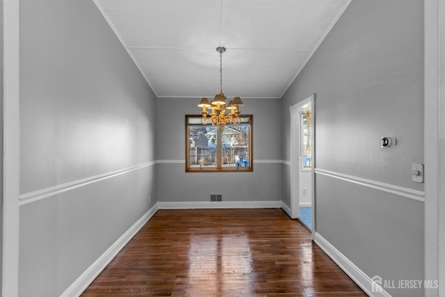 unfurnished dining area featuring visible vents, dark wood finished floors, lofted ceiling, crown molding, and a notable chandelier