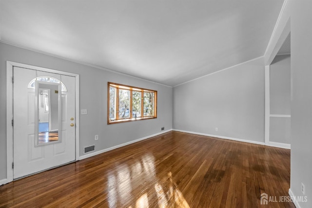 foyer with baseboards, crown molding, visible vents, and wood finished floors