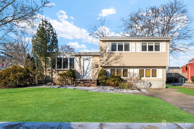 split level home featuring entry steps and a front lawn