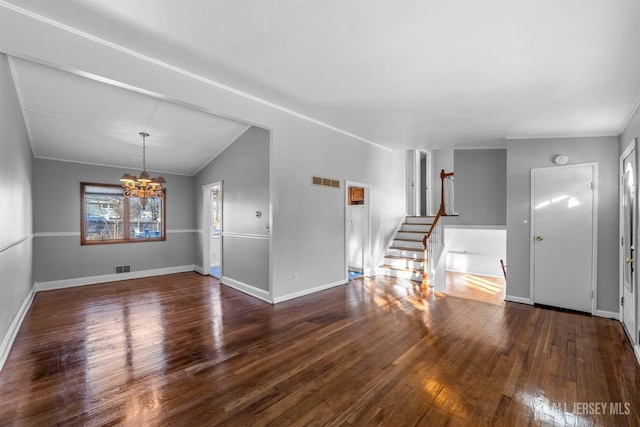 entrance foyer with stairway, wood finished floors, visible vents, and an inviting chandelier