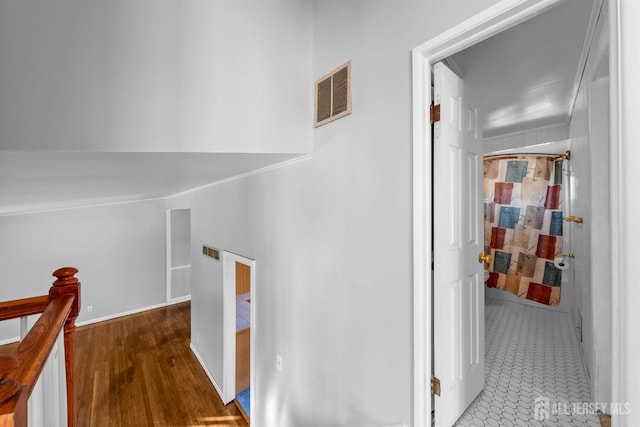 hallway featuring visible vents and an upstairs landing